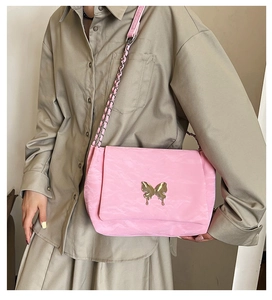Pink butterfly shoulder bag with gold metal buckle and chain strap on a model