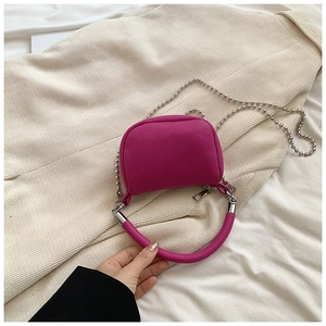 Detail of fuchsia mini crossbody bag with litchi texture and silver bead chain strap