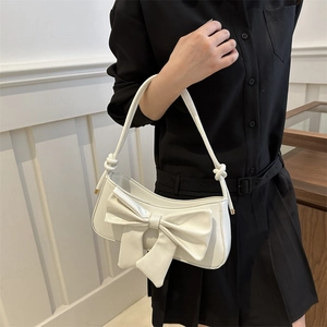 Glossy white patent leather underarm bag with large bow and knot strap detail for women