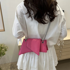 Chic pink irregular faux leather shoulder bag with silver chain strap shown on model
