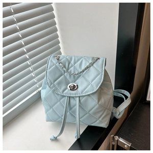 Detail of light blue quilted mini backpack with silver chain and twist lock closure