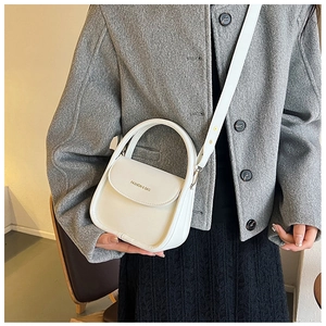 Sac bandoulière blanc en cuir minimaliste avec logo doré sur le rabat frontal