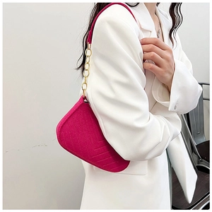 Close-up of rose red felt shoulder bag featuring V-shaped stitching and gold chain strap