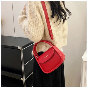 Red retro small square bag with gold lettering shown in a stylish crossbody carry pose