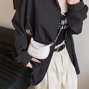 White mini crossbody bag with silver star rivets and pearl chain strap on a model