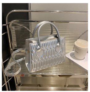 Detailed view of silver quilted tote bag featuring geometric patterns and metallic finish