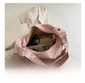 Pink pleated crossbody bag interior showing storage for phone, cardholder, and sunglasses