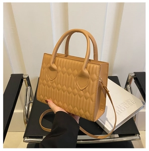 Detailed view of the diamond quilted pattern and texture on the khaki crossbody handbag