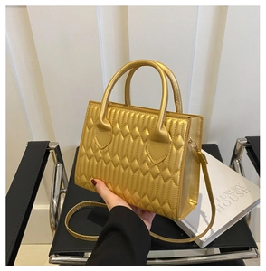 Close-up of golden quilted handbag showing luxury diamond texture and metallic luster