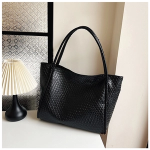 Close-up of black woven tote bag showing detailed texture and high-quality synthetic leather