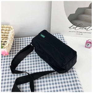 Detail of black nylon crossbody bag with adjustable wide strap and EAIMT green label