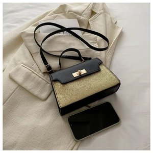 Detail of contrast sequin crossbody bag with metal lock shown next to a smartphone