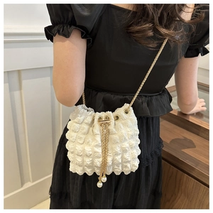 Detail of white bubble pleated bucket bag with gold chain strap and pearl drawstring