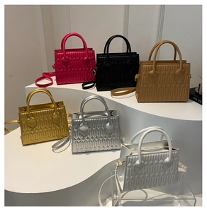 Detail view of small square tote bags in six colors with geometric quilted texture