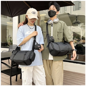Outdoor lifestyle shot showing two black matte waterproof fitness bags in different sizes