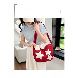 Détail du sac cabas rouge en toile avec écussons étoiles et bandoulière réglable