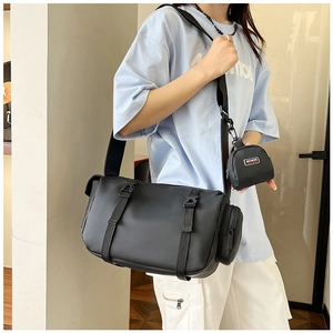 Close-up of black technical crossbody bag with round mini pouch and nylon straps