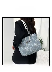 Détail du cabas floral avec bandoulières en cuir blanc, perle et chaîne métallique