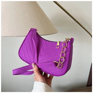 Detail of purple felt shoulder bag with chevron stitching and gold chain strap
