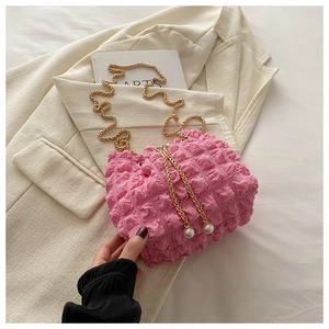 Detail of pink bubble texture bag with golden chain and elegant pearl pendants
