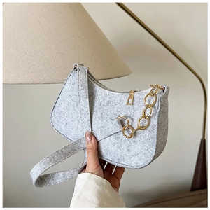 Close-up of grey felt shoulder bag featuring a stylish thick golden chain strap detail