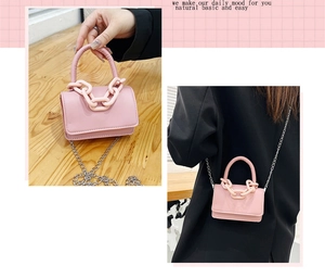 Détail du mini sac bandoulière rose avec chaîne décorative en plastique et sangle métal