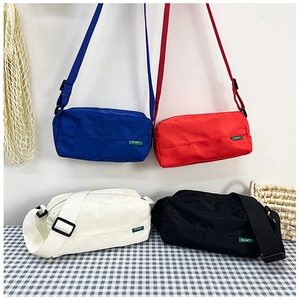 Detailed view of four colorful nylon crossbody bags with adjustable straps and EAIMT labels