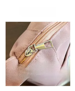 Détail du sac fourre-tout en nylon rose avec fermeture éclair argentée et coutures
