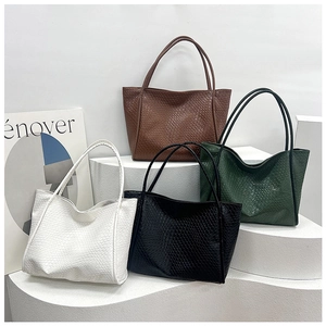 Minimalist woven tote bags in black, white, brown and green on display stands