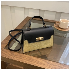 Detail showing high-shine gold glitter and black leather contrast with metal lock closure