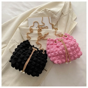 Detailed view of bubble popcorn fabric texture and pearl drawstring on mini bucket bags