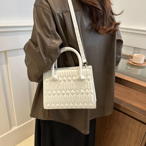 White quilted crossbody bag with golden hardware and circular handle for women