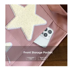 Vue macro d'un cabas rose avec un patch étoile et une poche avant pour un smartphone