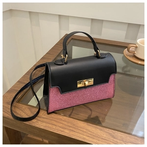 Macro view of contrast color crossbody bag featuring pink glitter and gold turn-lock