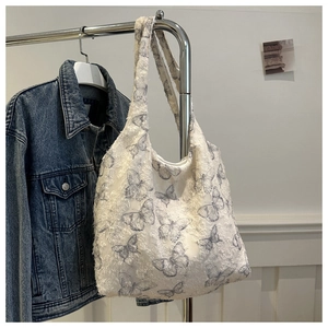 Détail du sac fourre-tout blanc avec imprimé papillon bleu et texture douce