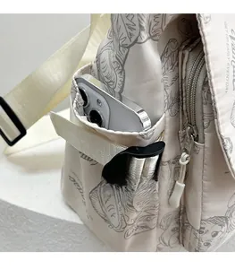 Detail view of water-resistant nylon tote bag side pocket with buckle and smartphone
