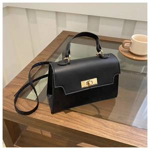 Detail of black crossbody bag featuring matte suede and smooth faux leather stitching