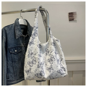 Détail du sac hobo en peluche blanche avec motif papillon bleu pour l'automne-hiver