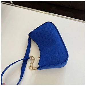 Detail of Klein blue felt bag with V-shaped quilting and golden chain strap