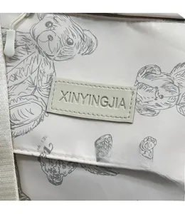 Detail view of water-resistant nylon fabric with bear print and brand logo patch