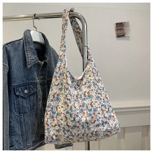 Détail d'un grand sac cabas en toile à fleurs bleues suspendu dans un décor de style de vie