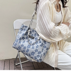 Détail du sac cabas à fleurs bleues avec bandoulière en perles et texture plissée