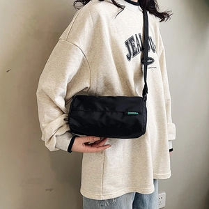Fashionable black nylon cylinder crossbody bag with adjustable wide shoulder strap for women