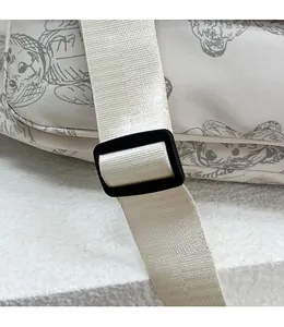 Detail of adjustable nylon strap and black plastic buckle on printed tote bag