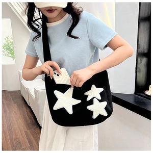 Détail du grand sac cabas noir en toile avec étoiles en peluche et un smartphone