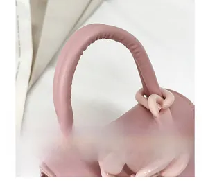 Détail de la poignée en cuir PU rose et chaîne en résine épaisse sur un sac bandoulière