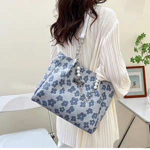 Détail du sac cabas floral avec bandoulière en cuir blanc, chaîne et perles décoratives
