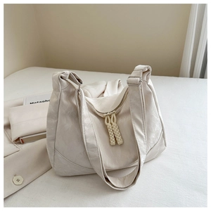 Detail of cream hobo bag with unique wrinkled texture and double zipper accents