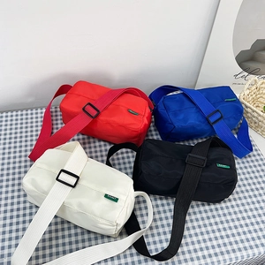 Lightweight nylon crossbody pillow bags in red, blue, beige, and black with wide straps