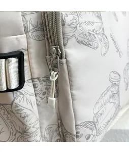 Detailed macro view of the water-resistant nylon fabric with printed slogan and metal zipper